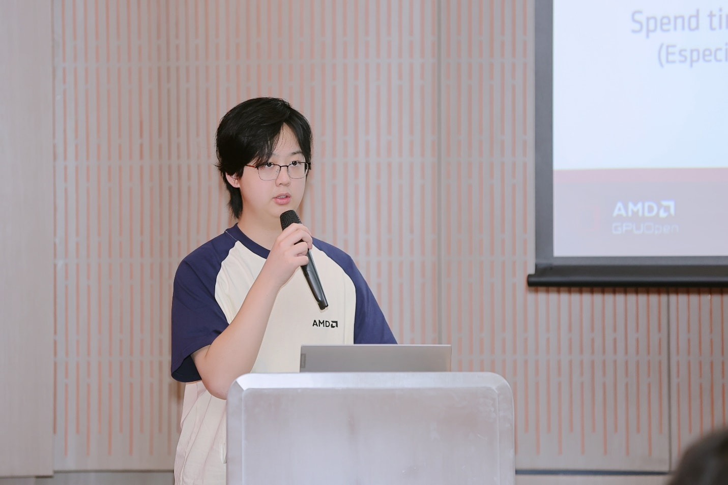 A person standing in front of a podium holding a microphone